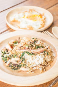 Rice topped with stir-fried squid basil and fried egg (Thai food), stock photo