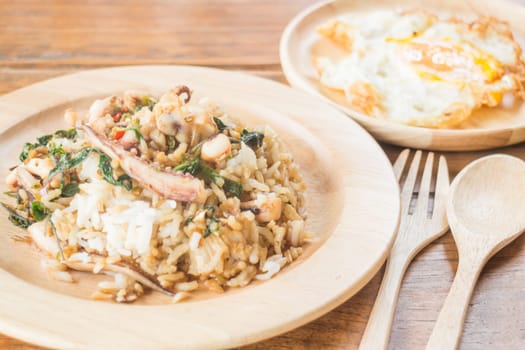 Rice topped with stir-fried squid basil and fried egg (Thai food), stock photo