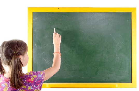 First grade pupil a girl writing on green blackboard isolated on white background
