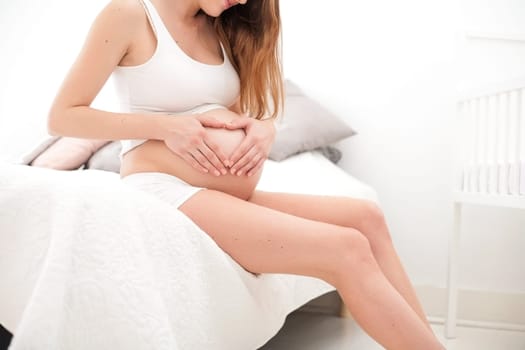 Young new mother is sitting on a bed