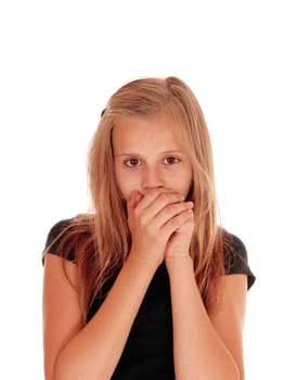 A pretty blond slim girl holding her hands over her mouth, looking.scared, isolated for white background..