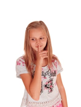 A lovely blond young girl standing for white background holding her.finger over her mouth, don't talk..