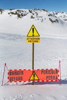 Pedestrians passing a ski slope in the mountains