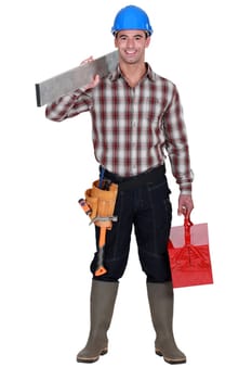 Worker carrying an aluminium plank and a toolbox