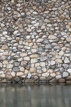 Old stone fortress wall with foss water