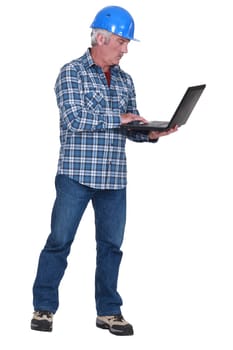 middle aged craftsman standing with laptop