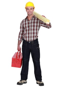 craftsman holding a board and a tool box