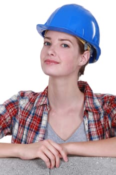 Female mason stood by unfinished  wall
