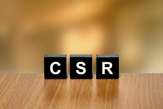 CSR or Corporate social responsibility on black block with blurred background