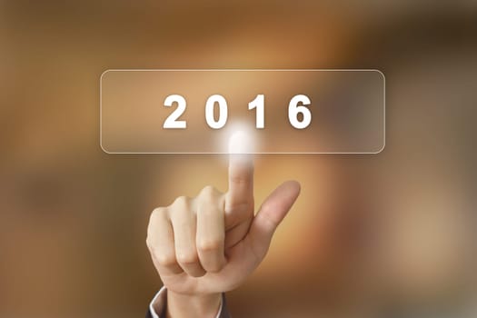 business hand pushing 2016 happy new year button on blurred background