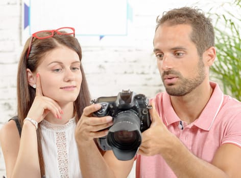 young couple looking at pictures on camera