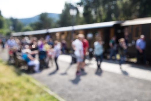 out of focus shot of passengers at a trainstation, entering and leaving the train, shot in summertime