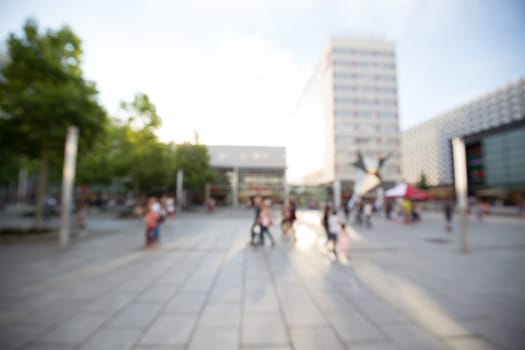 Out of focus shot of a shopping street in summer, people shopping
