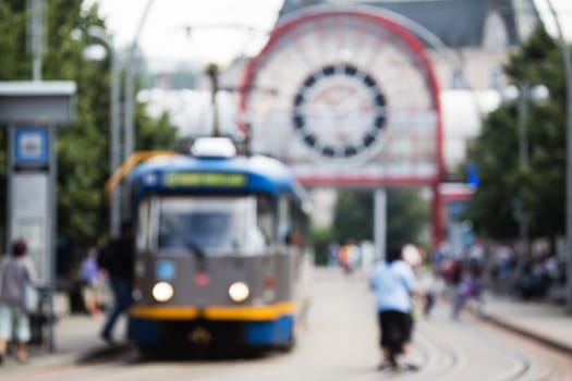 Out of focus shot of city street life, public transport and people using it. pedestrians walking about