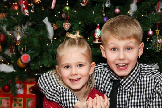 Young boy and young girl happy and looking at camera on christmas day