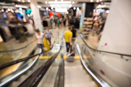 Out of focus shot of people using stair inside a fashion shop, shot from the top