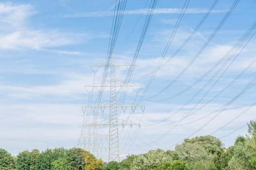 High voltage towers with blue skies in the background.
