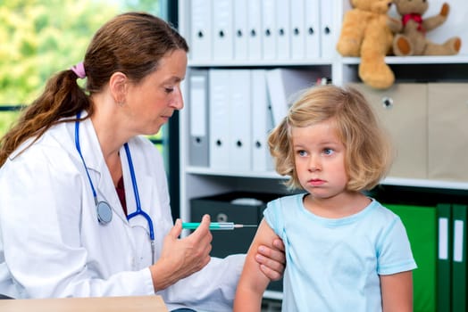 female pediatrician in white lab coat injected a medicament