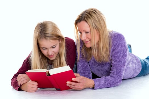 blond girl and her mother lying on the floor and reading a book