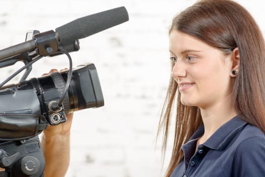a young smiling woman journalist looks at the camera
