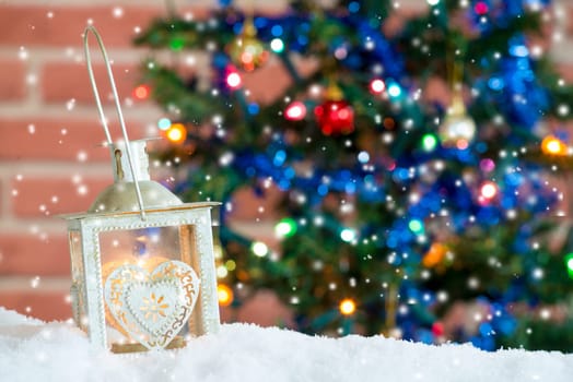a Christmas background with burning lantern in the snow and bokeh