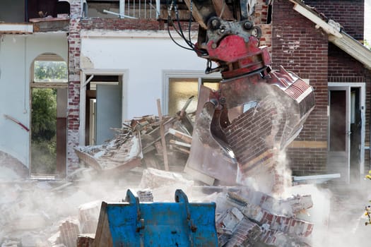 Demolishing an abandoned house with a grab