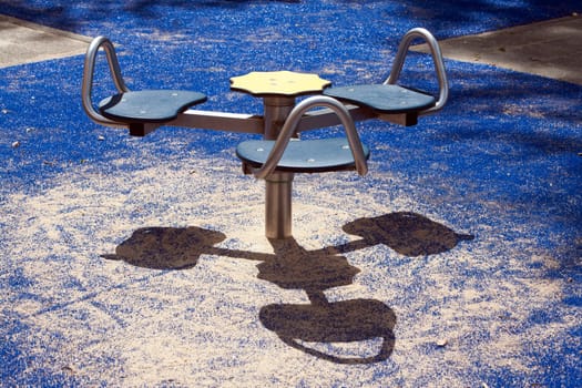Carousel in a children playground with smiling shadow