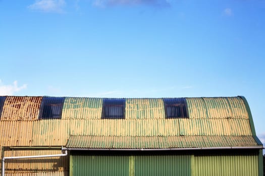 Old yellow green shed made from corrugated iron sheets