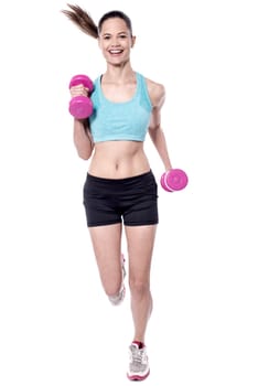 Fit woman in action, holding dumbbells.