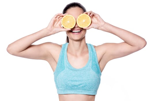 Fit young woman showing sliced orange