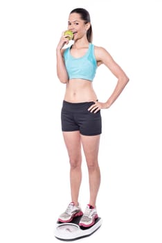 Fit young slim woman standing on weight machine
