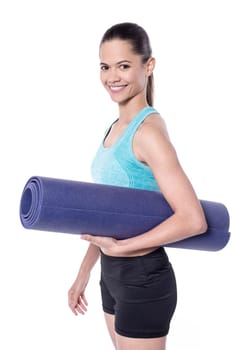 Young slim woman holding exercise mat