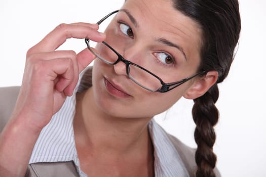 A businesswoman taking her glasses off.