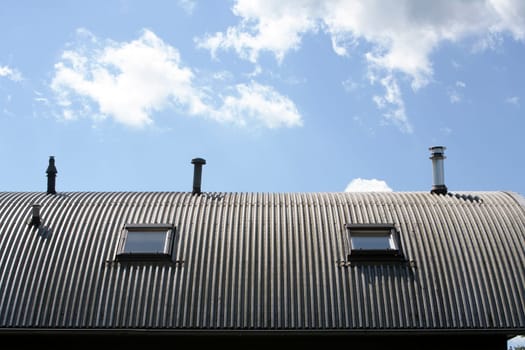 Corrugated metal roof with windows and chimneys