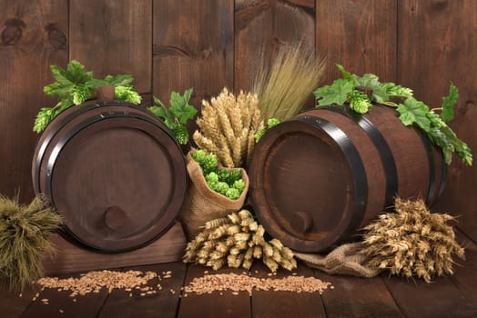 Two beer barrels with wheat,barley,hops and malt