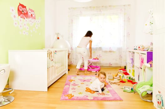 Young mother with baby in the nursery