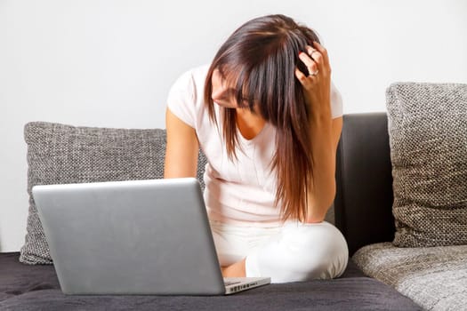Thoughtful young woman on computer