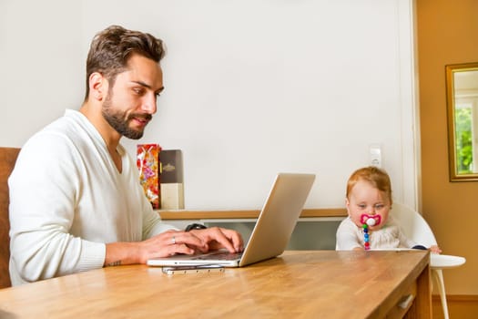 Father works at home on the computer