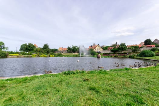 Pond in Almedalen, Visby, Sweden with birds and cloudy sky.