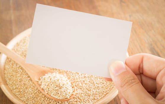 Organic quinoa grain and hand on business card, stock photo
