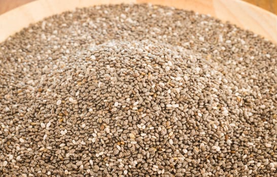Nutritious chia seeds on a wooden plate, stock photo