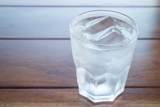 Glass of cold water on wooden table, stock photo