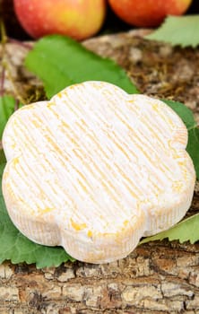 french cheeses with several apples in the background