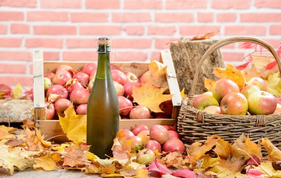 a bottle of Normandy Cider, with many apples and basket