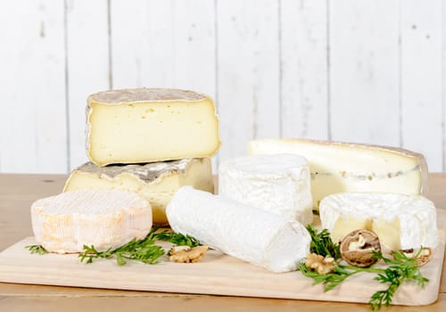 different french cheeses placed on old table