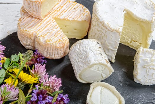 different french cheeses placed on a black slate