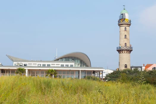 Lighthouse and tea kettle behind a meadow on the beach of Warnemünde