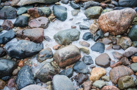 The freezed stones on coast of Baltic sea. A winter landscape