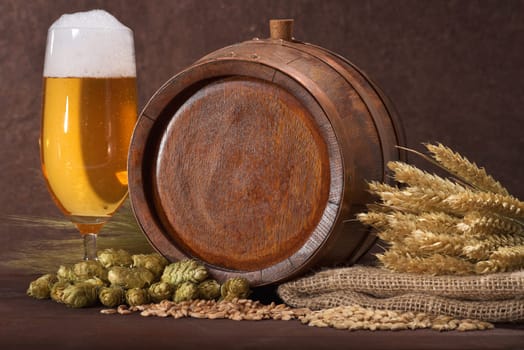 Old wooden barrel with beer glass,wheat,barley,hops and malt