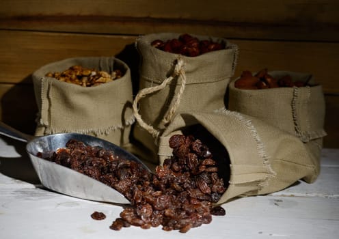 dried currants in a canvas bag on white wooden table